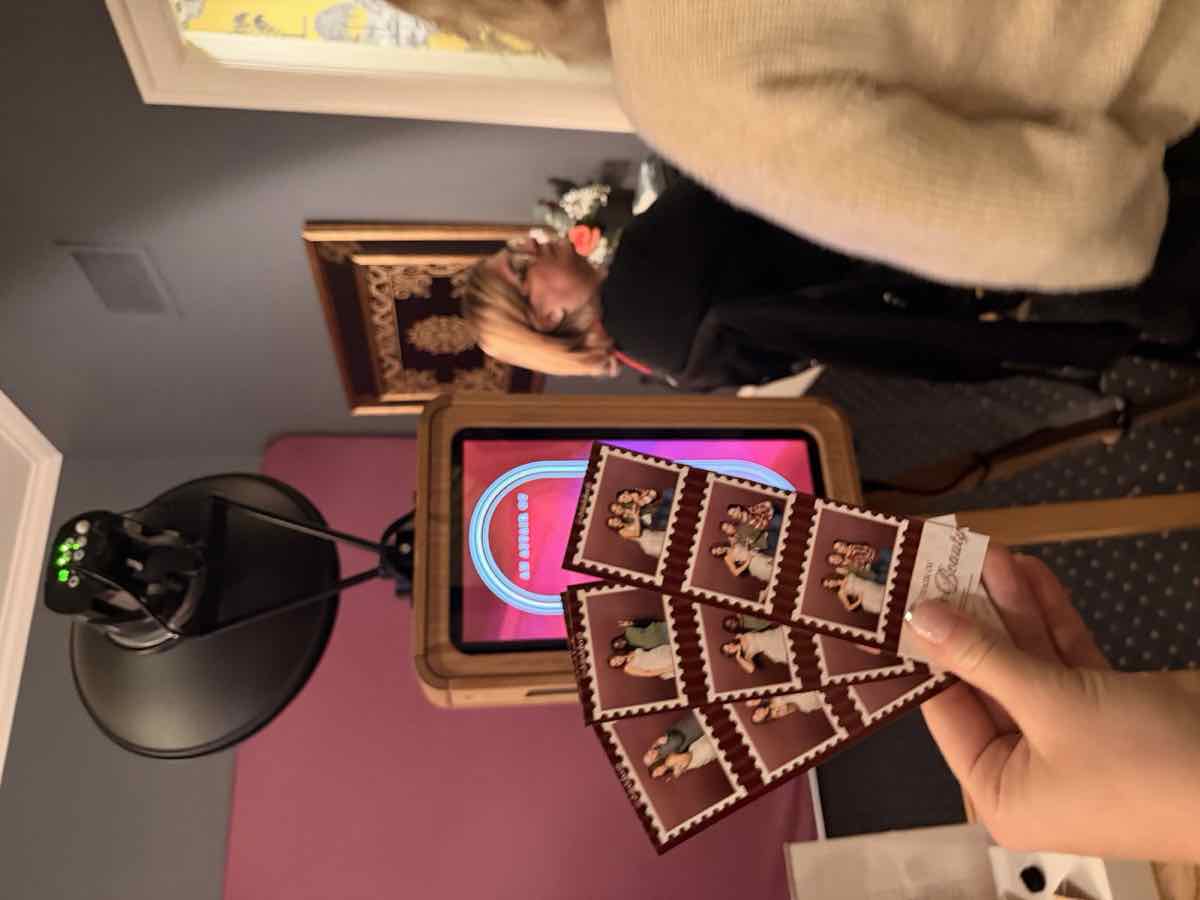 Photo-booth strips held up in front of the event photo booth
