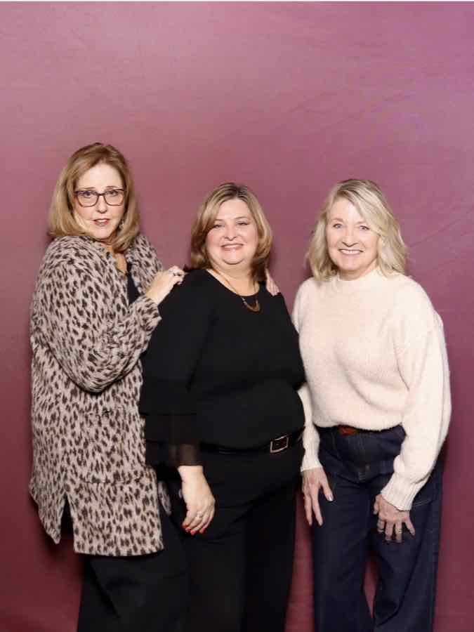 Three guests posing together at the photo booth