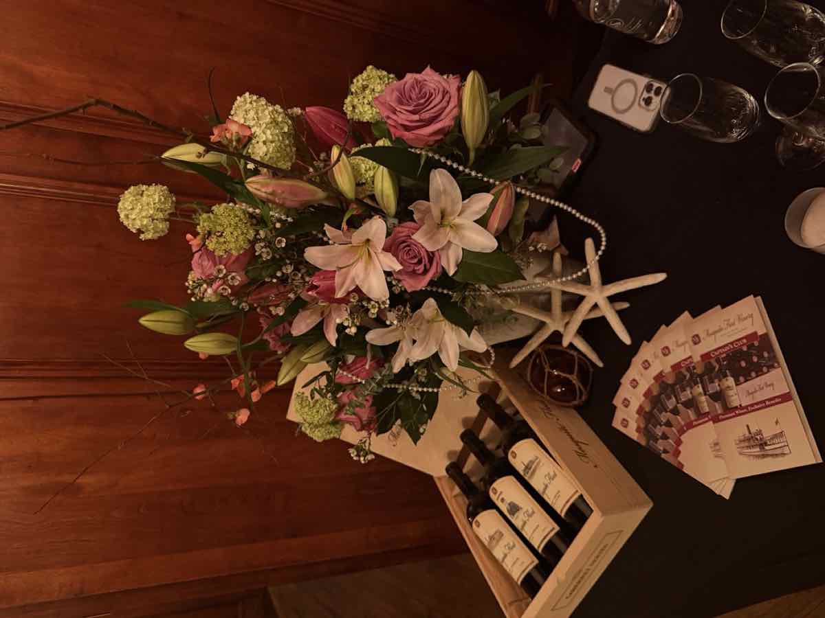 A wine tasting table with flowers and a wooden wine crate