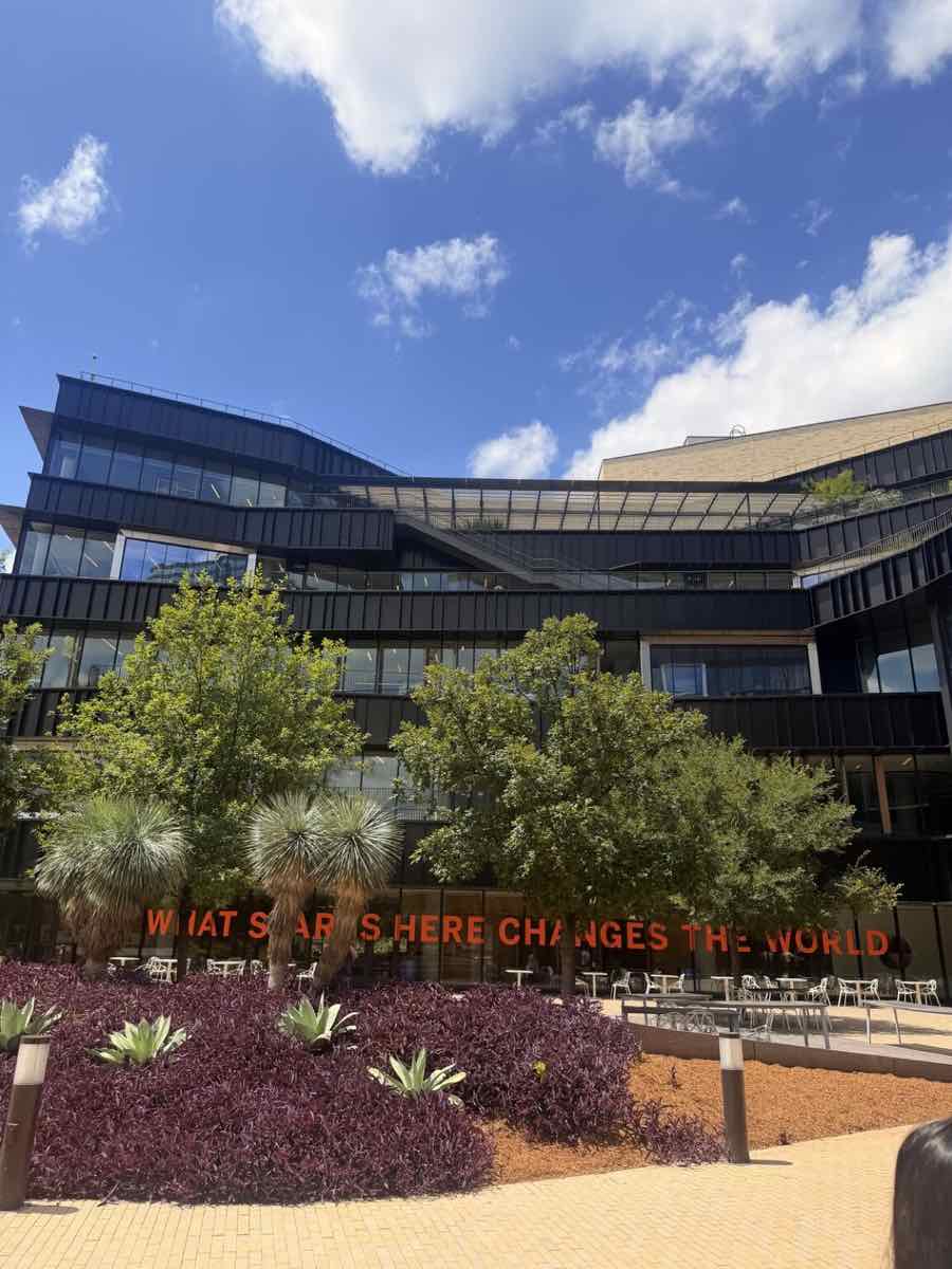 A UT Austin building with the sign What Starts Here Changes the World