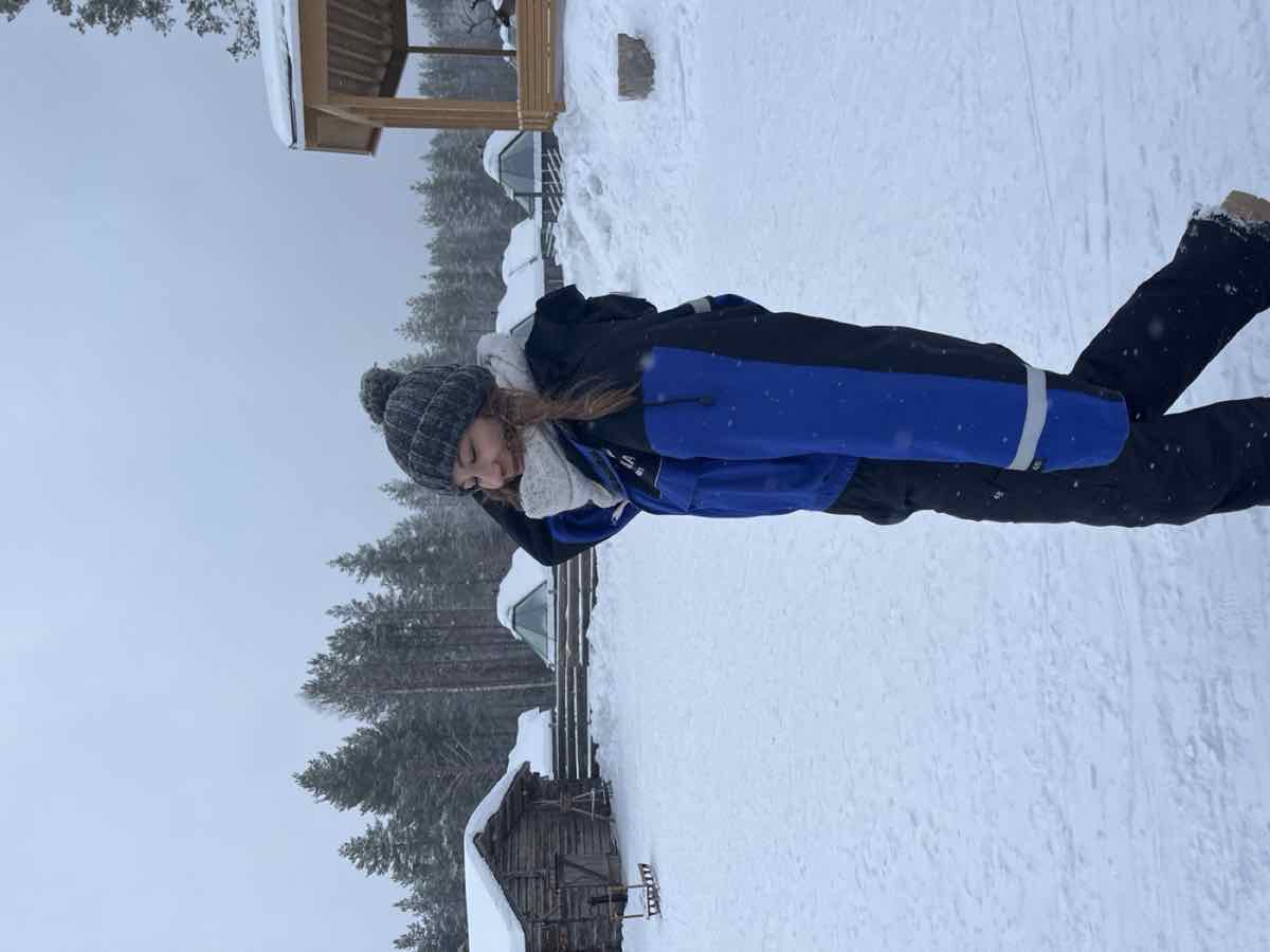 Taylor walking through the snow in a blue snowsuit
