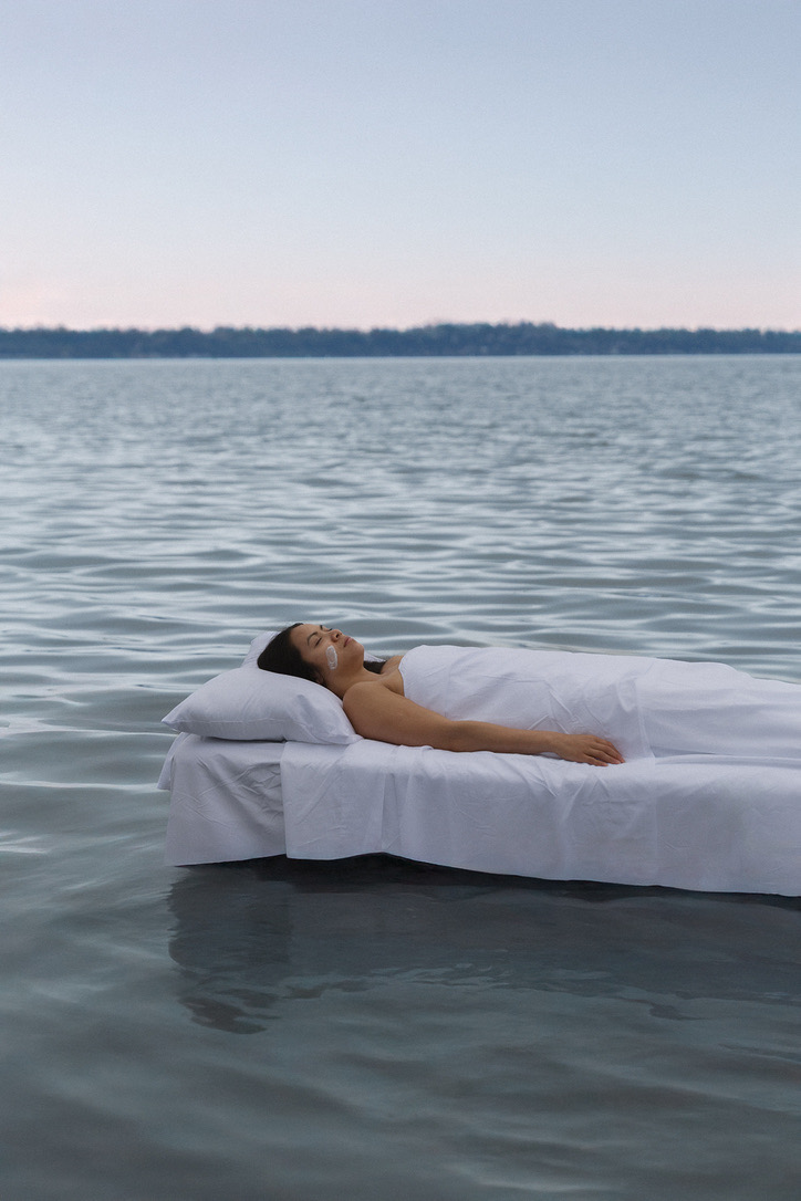 Final image: model on a white bed floating on the lake