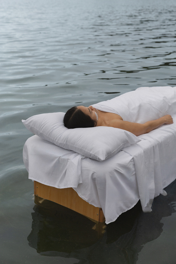 Close view of a model resting on a white bed floating on the lake